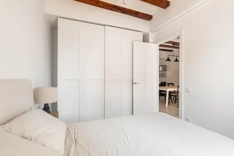 Large wardrobe and soft bed in white minimalist bedroom Stock Photos