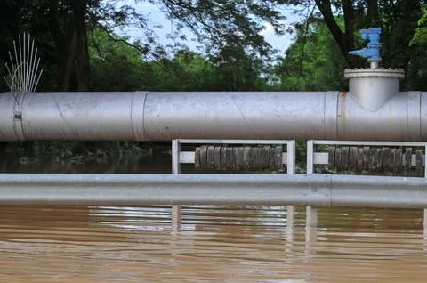 A large water pipe crosses the river Foto stock