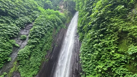 Large Waterfall Cascading Down Rocky Cliffs on Bali Island in Cloudy Day Stock-Footage 339983128