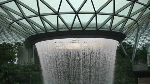 A large waterfall is flowing from the ceiling of a building Видео 317308284