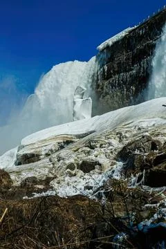 Large waterfall flowing over rocks in a cold icy landscape Stock Photos