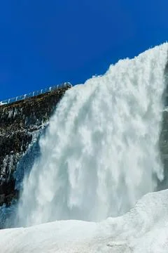 Large waterfall flowing over rocks in a cold mountain scene Stock Photos