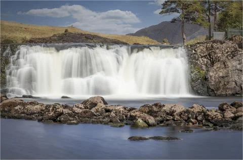 Large waterfall flowing over some rocks Stock Photos