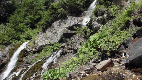 Large waterfall with rocks and vegetation Stock Footage 70573906