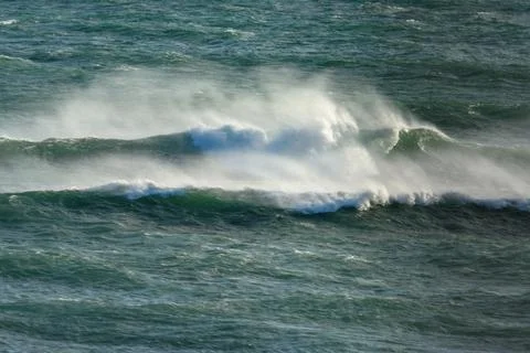 A large wave breaking on the shore with dramatic foam and misty spray Stock Photos