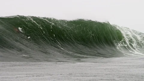 Large wave stands up before exploding onto a rock shelf barrelling and Stock Footage 127486821