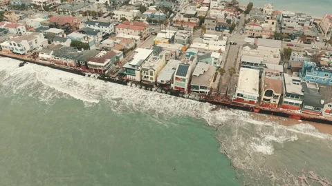 Large waves break along a row of beachfront homes on the Long Beach peninsula Stock Footage 347620265