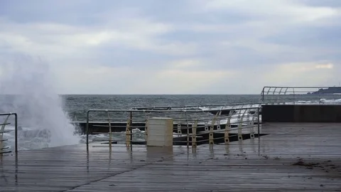Large waves broken down with great force on the pier in slow motion Video stock 83506315