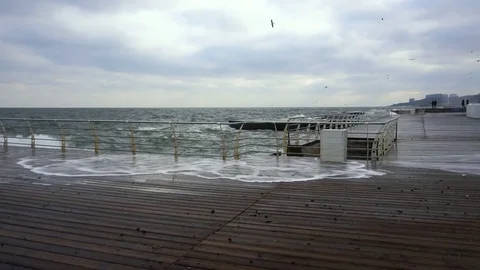 Large waves broken down with great force on the pier in slow motion Video stock 83506375