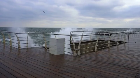 Large waves broken down with great force on the pier in slow motion Video stock 83506545