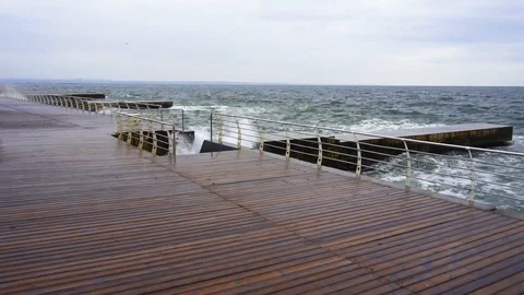 Large waves broken down with great force on the pier in slow motion Video stock 83506909