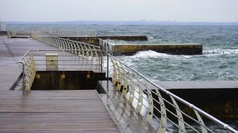Large waves broken down with great force on the pier in slow motion Video stock 83507003