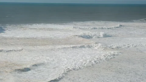 A large Waves Crashes Against a Rock on the ocean shore Stock Footage 304976198