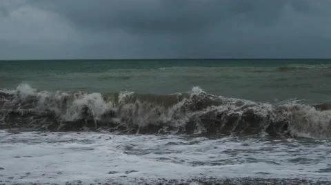 Large waves in the dark sea breaking on the shore with the formation of spray Stock Footage 62890638