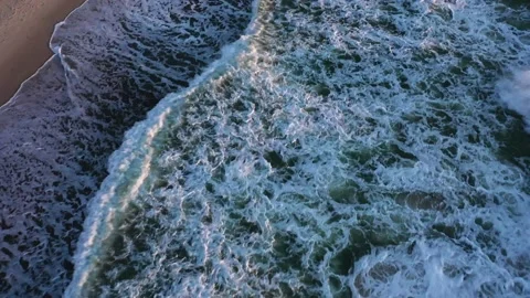 Large waves with foam roll on empty sandy beach at sunset Stock Footage 148782541