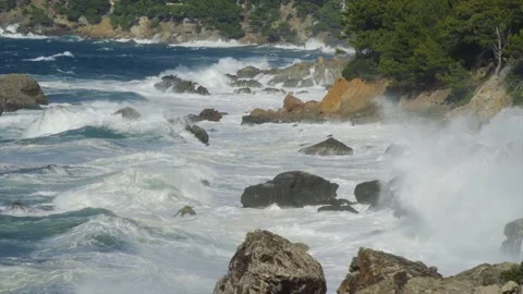 Large waves hitting Mediterranean coastal rocks creating white foam Stock Footage 168801668