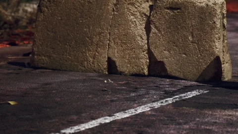 Large Weathered Stone Block Resting on a Dark Asphalt Surface During Daylight Stock Footage 348112215