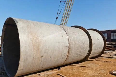 Large welded pipe lies at the base of the metal Stock Photos