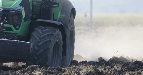 Large wheels of the tractor that pulls plug and plows dry field Stock Footage 118712999