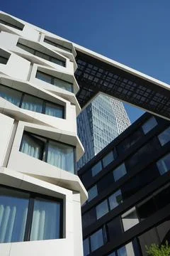 A large white and black building and some buildings with a sky background Fotos de archivo
