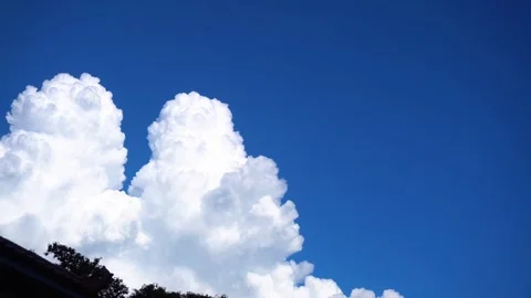 Large white autumn clouds drifting slowly across a deep clear blue sky Stock-Footage 347041622