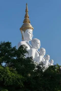 Large white buddha statue with multiple heads in a forest Stock Photos