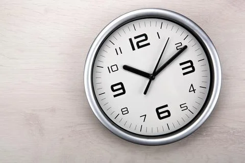 Large white clock face with digits on a wooden background closeup Stock Photos