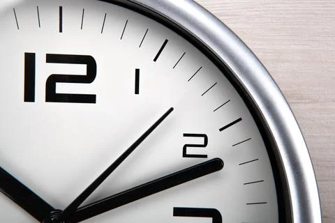 Large white clock face with digits on a wooden background closeup Stock Photos