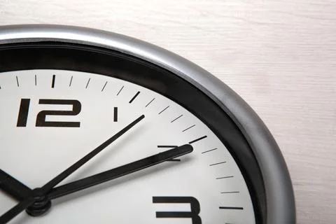 Large white clock face with digits on a wooden background closeup Stock Photos