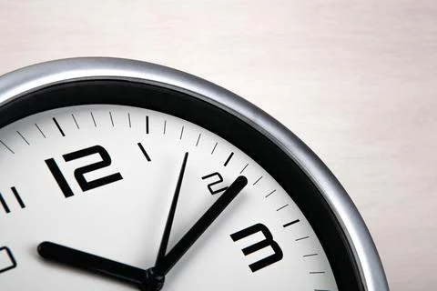Large white clock face with digits on a wooden background closeup Foto stock