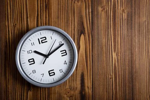 Large white clock face with digits on a wooden background top view Stock Photos