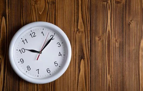 Large white clock face with digits on a wooden background top view Stock-Fotos