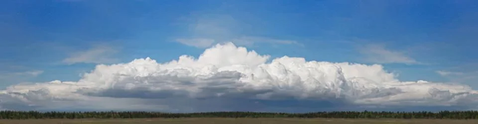 Large white cloud floating over a clear blue sky 스톡 사진