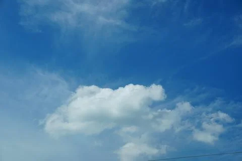 A large white cloud floats in a blue sky Stock Photos