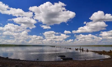 Large white clouds are reflected in the salt water of the Kuyalnitsky estua.. Stock Photos