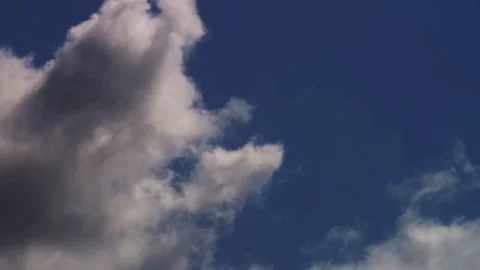 Large white clouds evolve against a deep blue sky Stock Footage 329756256