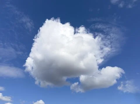 Large white cumulus cloud in a blue sky. Bright cloudscape with open daylight Stock Photos