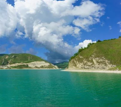A large white Cumulus cloud rises above the high-mountain lake Kezenoi Am in  Stock Photos