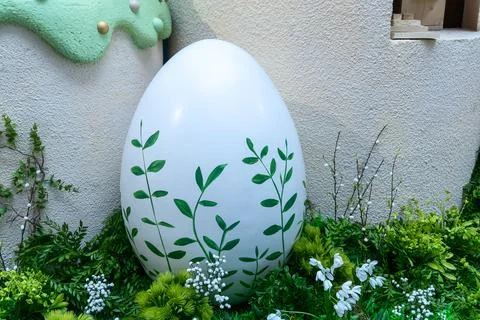 Large white easter egg decorated with green leaves in garden. Spring festiv.. Stock Photos