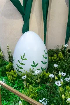 Large white easter egg decorated with green leaves in garden. Spring festiv.. Stock Photos