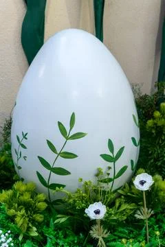 Large white easter egg decorated with green leaves in garden. Spring festiv.. Stock Photos