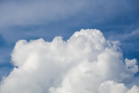 Large white fluffy cumulus cloud formation under blue sky Stock Photos