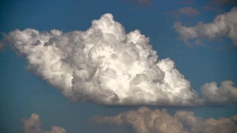 Large white fluffy cumulus clouds moving across blue sky on sunny day. Stock Footage 341250177