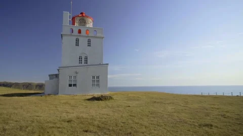 Large white lighthouse on Cape Dyrholaey. Lighthouse building on the edge of a Stock Footage 130447229