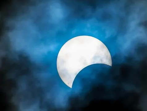 A large white moon is visible in the sky, with a blue and cloudy background Stock Photos