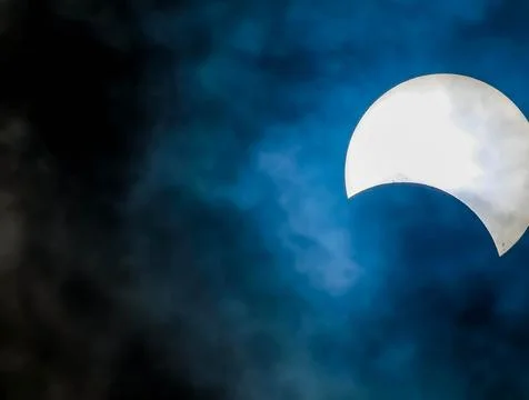 A large white moon is visible in the sky, with a blue and cloudy background Stock Photos