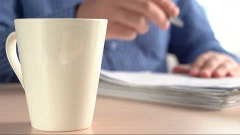 Large white mug. In the background Writes documents with a pen. Stock Footage 151920579