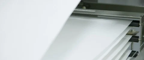 Large white paper going over multiple rollers on a metal feeding machine Stock Footage 112893393