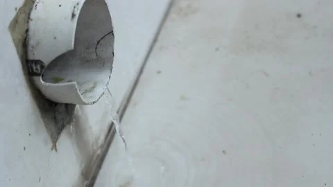 A large white pipe drains a small amount of rainwater Stock Footage 246429251