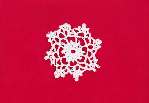 A large white snowflake on a red background with copy space Stock Photos